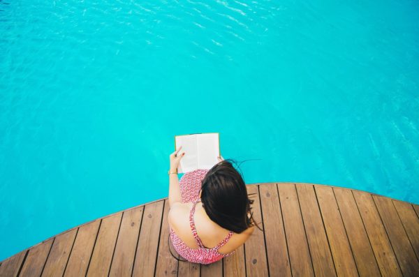 Woman reading by Pool | Legacy At Fort Clarke | Apartments In Gainesville, FL